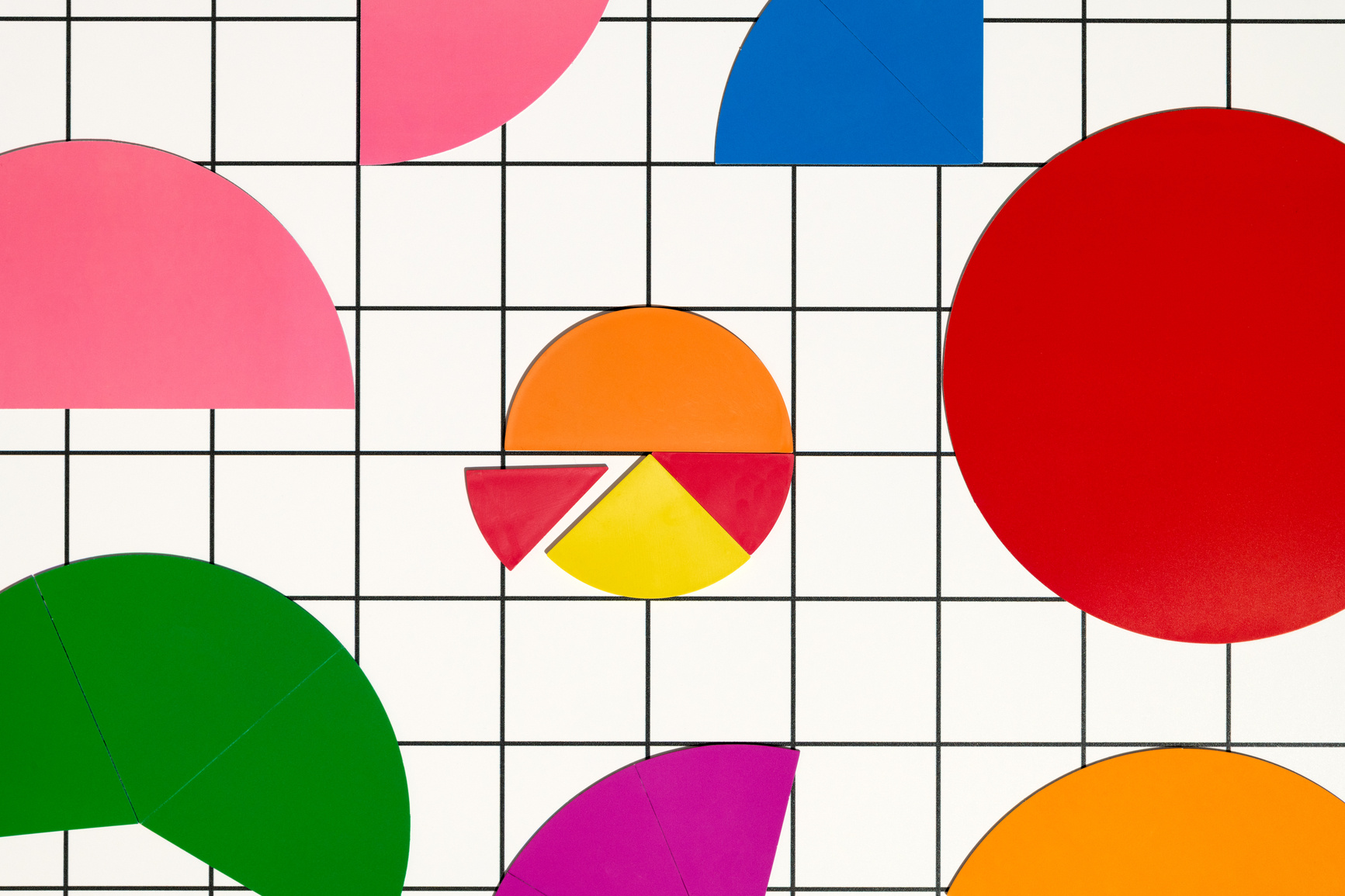 Circles, broken up into slices of different colours, on top of a black and white grid background