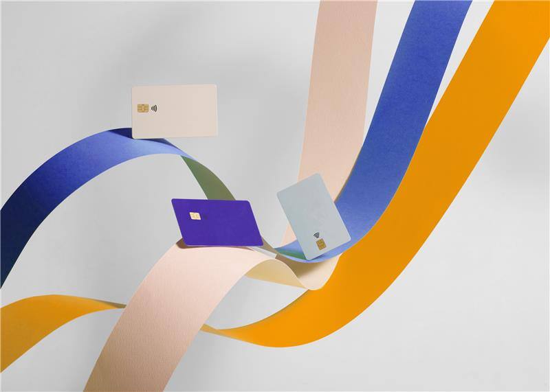 Illustrated debit cards, riding on swirling, colourful ribbons