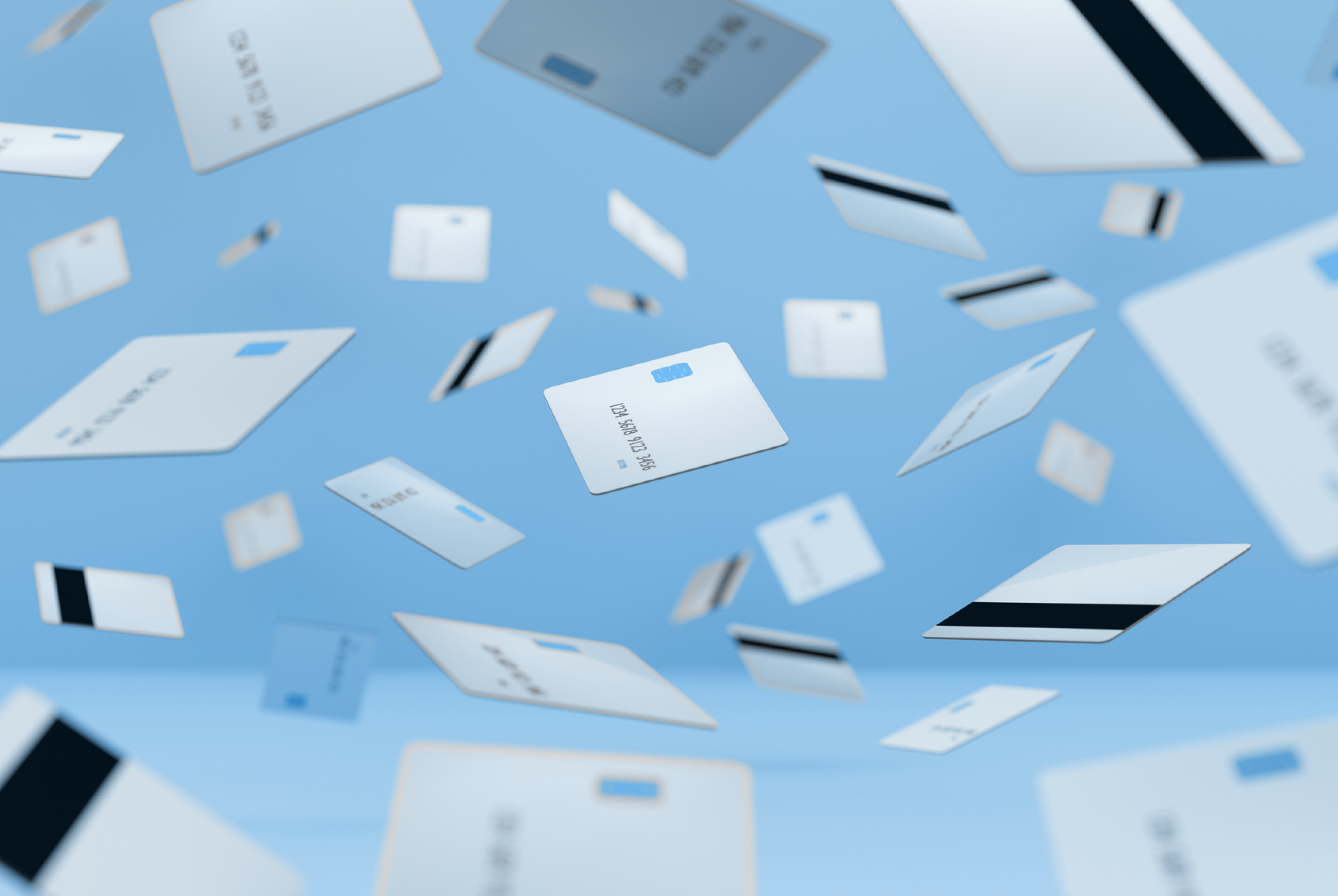 An array of silver bank cards rain down against a light blue background