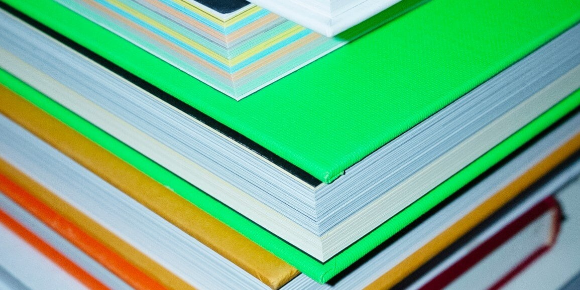 A stack of colourful books, placed on jaunty and uneven angles