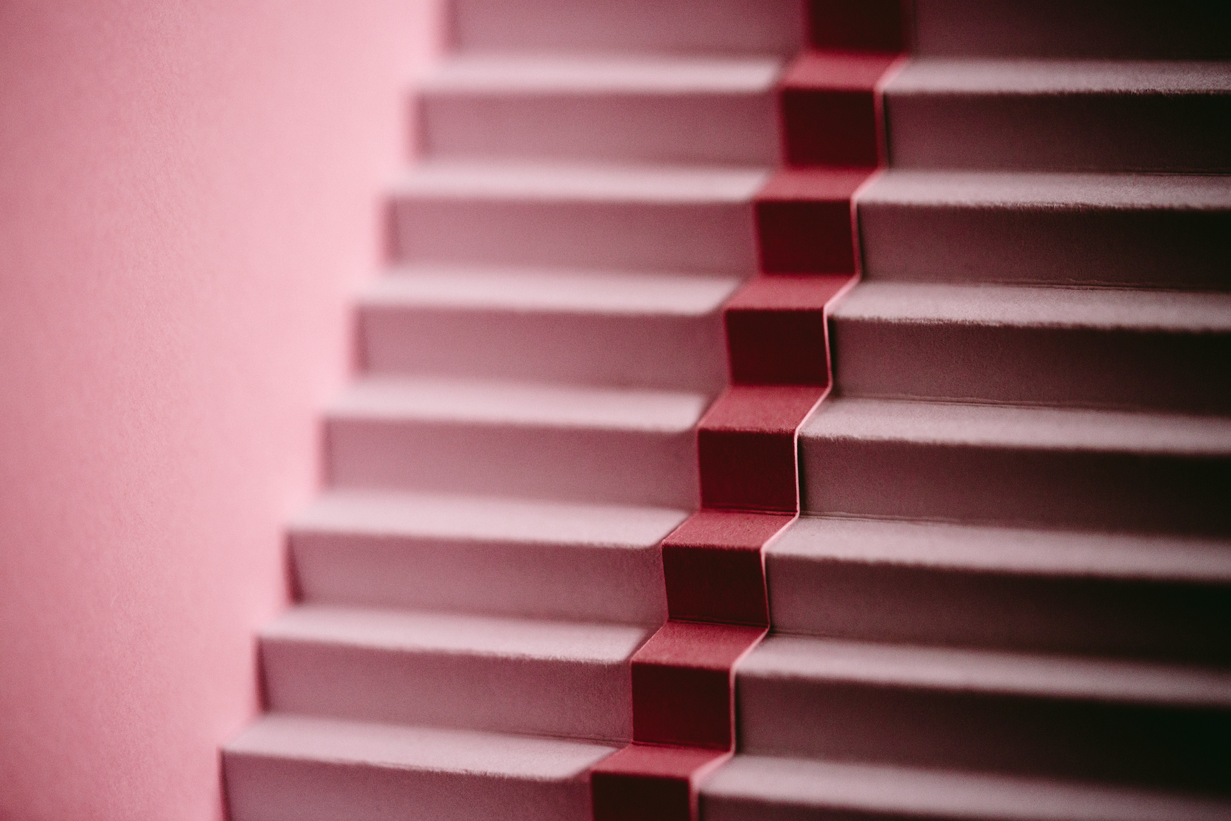 A set of steep, dusky pink stairs, with a darker pink stripe running down the centre